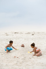 Fototapeta na wymiar Children burying father in sand