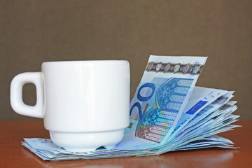 Tasse de café avec liasse de 20 euros 
