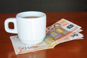 Tasse de café avec billets de 50 euros 