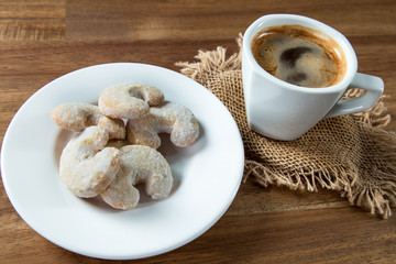 Christmas sweet rolls with coffee on brown wooden background.