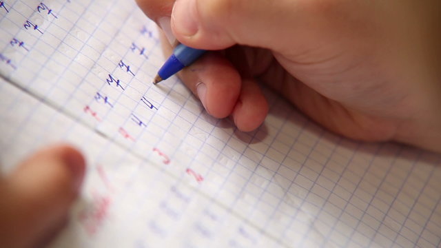 A footage of a pupil making his first steps in writing and arithmetic
