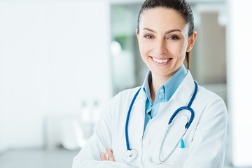 Confident female doctor posing in her office