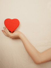 Closeup of heart shape box in woman hand