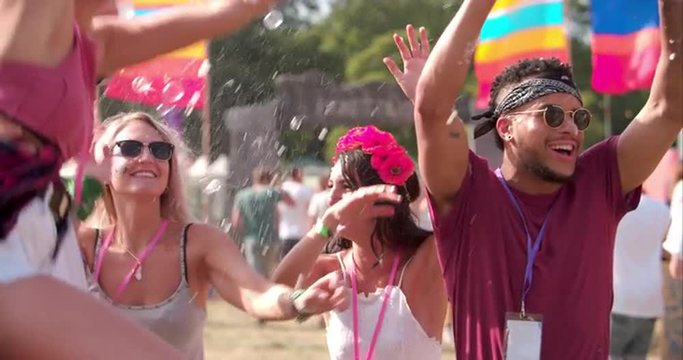 Friends enjoying bubbles at a music festival, slow motion