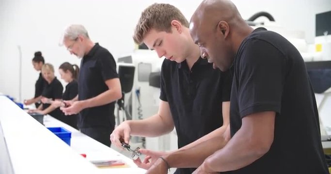 Engineer In Factory With Apprentice Checks Component Quality