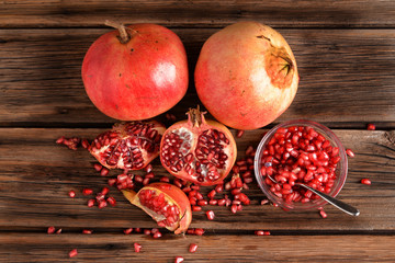 Pomegranate and glass bowl with beans on wooden board