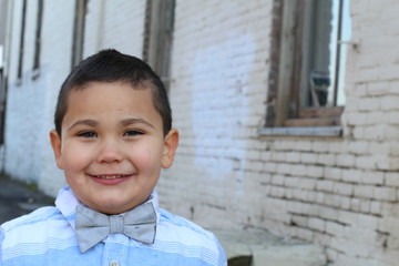 Four years old boy wearing a fancy bow tie with copy space on the right 