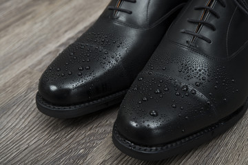 濡れた男性用の黒い革靴