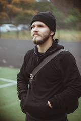 Muscular male athlete taking break standing relaxing after training