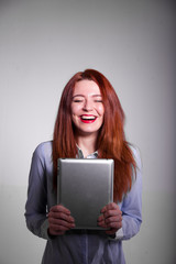 Happy woman with red hair and tablet