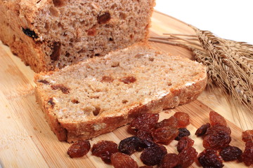Fresh baked bread, ears of wheat and raisins