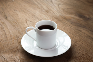 A cup of black coffee on the wood table