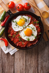 huevos rancheros closeup in the pan and ingredients, vertical top view

