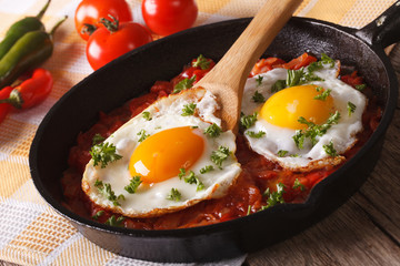 huevos rancheros: fried egg with salsa closeup in the pan. Horizontal
