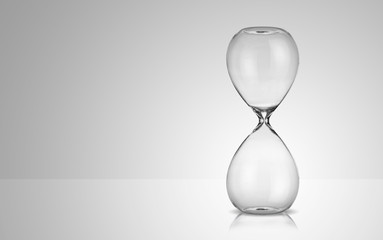 Empty hourglass on gray background - obrazy, fototapety, plakaty