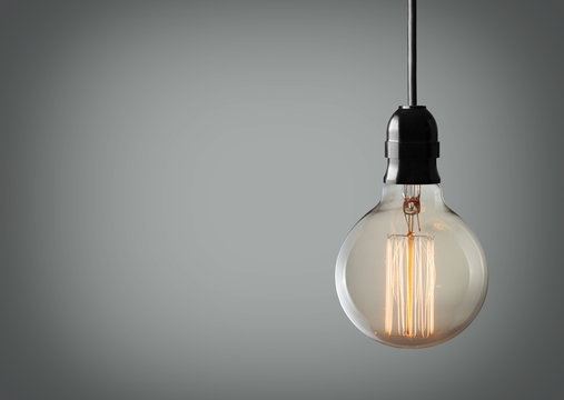 Vintage hanging light bulb over gray background