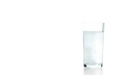 Hand throwing a tablet in glass with water 