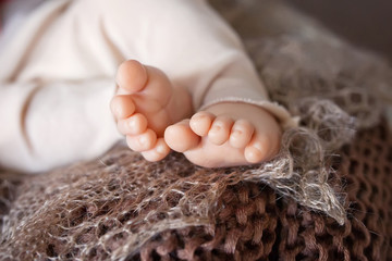 Close up picture of new born baby feet on a brown plaid