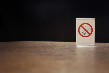 Plastic No smoking symbol on wooden table