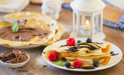 Christmas breakfast. Crepes with chocolate cream and berries.