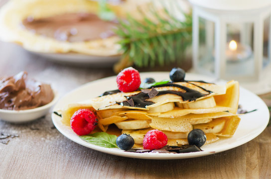 Christmas sweet breakfast. Crepes with chocolate cream and fresh