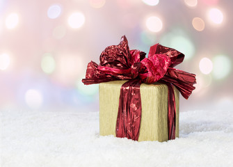Fototapeta premium Gift box with a red ribbon on snow