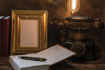Still life of vintage telephone with picture frame and diary on