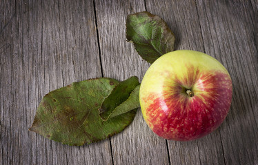 Apple with leaves on wooden background