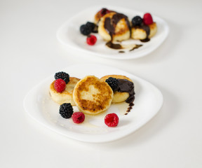 Cheese pancakes decorated with strawberry, honey and chocolate