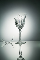 Broken crystal  glass with reflection on white illuminated backg