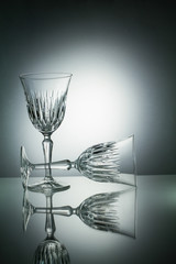 Two crystal  glasses with reflection on white illuminated backgr
