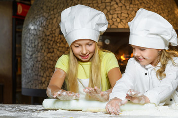 Making the dough for pizza is fun - little chefs playing with flour