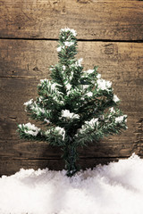 Besinnliche Karte mit Tannenbaum und Schnee vor Holzstruktur