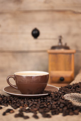 Kaffee in Tasse mit Kaffeebohnen, alter Kaffeemühle und antikem