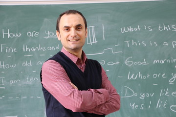The teacher in the classroom on greenboard background.
