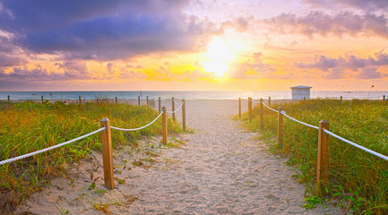 Path on the sand going to the ocean in Miami Beach Florida at sunrise or sunset, beautiful nature landscape, retro instagram filter for vintage looks - 97101973