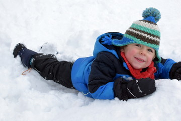 Cute boy plays in the snow