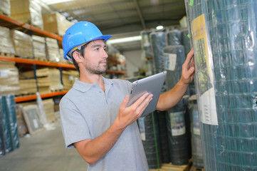 Man checking label on roll of fencing