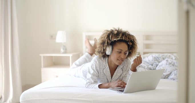 Woman Using Her Laptop In Bed