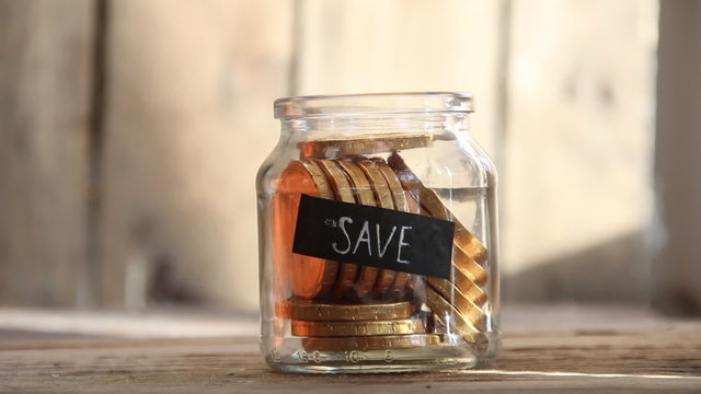 Save idea, gold coins in a glass jar and the inscription "SAVE"