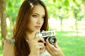 Girl taking photo with retro soviet no name camera outdoor, imag