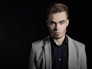 Portrait of attractive mysterious young man over black backgroun