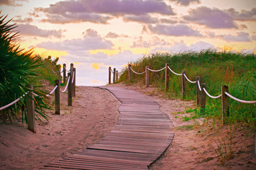 Path on the sand going to the ocean in Miami Beach Florida at sunrise or sunset, beautiful nature landscape, retro instagram filter for vintage looks - 97106318