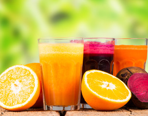 Fresh juice, mix fruits and vegetable, carrot, beetroot and orange drinks on wooden table. 