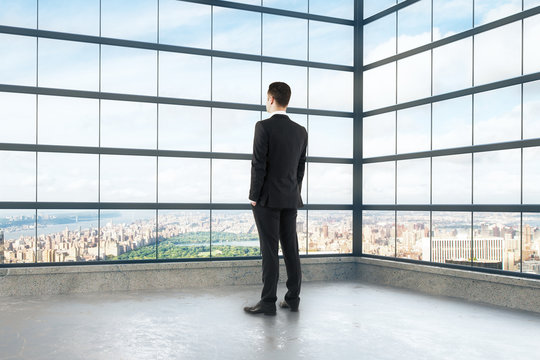 Businessman looking out the window of empty loft room
