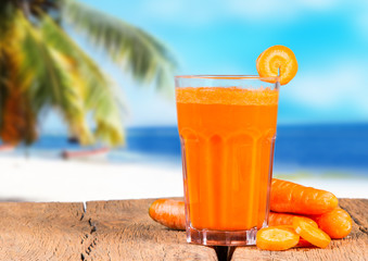 Glasses of carrot juice with vegetables on table