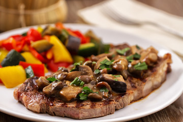 Grilled beefsteak with mushrooms and mixed vegetables.