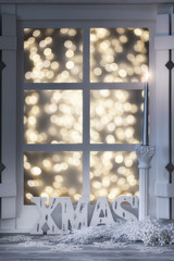 white window Christmas decorated with the candle light and bokeh lights