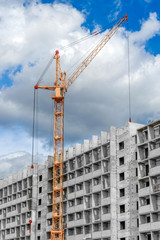 Fototapeta na wymiar Multi-storey houses under construction and big cranes