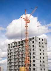 Fototapeta na wymiar High-rise building and high crane